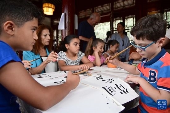 7月4日，在馬耳他桑塔露琪亞市的中國(guó)古典園林“靜園”，人們體驗(yàn)中國(guó)書法。新華社發(fā)（喬納森·博格 攝）