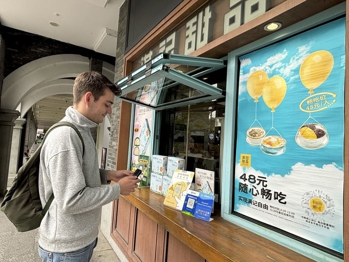 來自德國的留學(xué)生理查德在杭州西湖邊一家商鋪使用支付寶掃碼支付（2024年4月11日攝）。新華社發(fā)