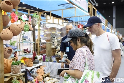 游客在蘭納博覽會特色展位上選購工藝品。人民網記者楊一攝