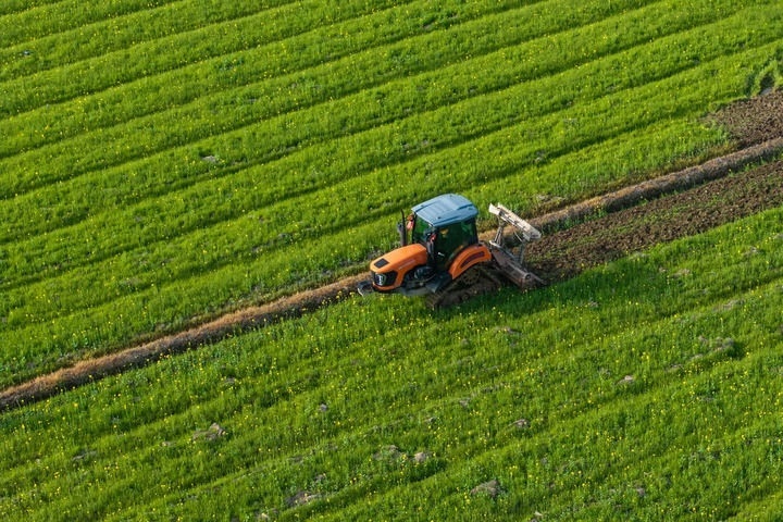 2024年3月19日，在湖南省常德市鼎城區(qū)謝家鋪鎮(zhèn)港中坪村，村民駕駛農(nóng)機(jī)翻耕田地（無人機(jī)照片）。新華社記者 陳思汗 攝