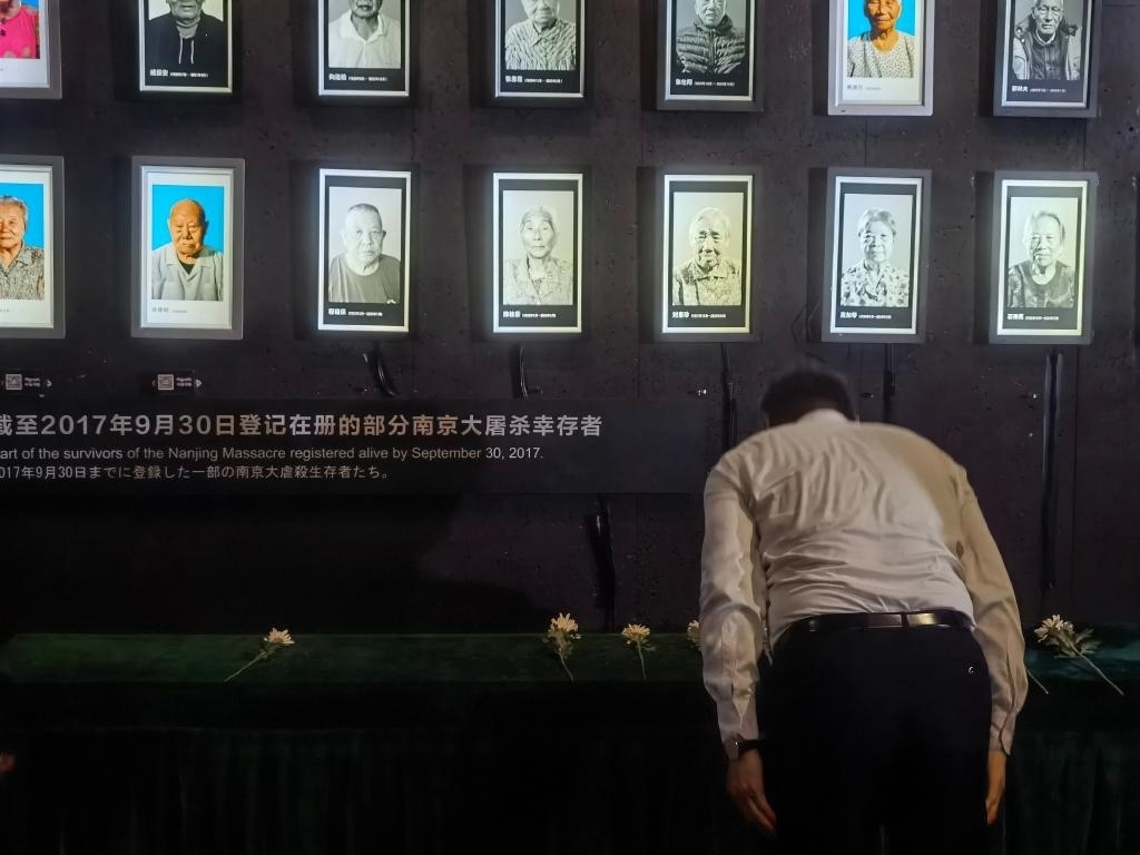 7月18日，人們向離世的南京大屠殺幸存者獻花、鞠躬。新華社記者邱冰清 攝