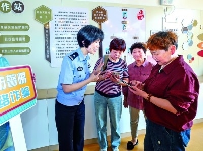 浙江湖州民警指導(dǎo)居民加入湖州“e企安”微信群，實(shí)時接收反詐信息。新華社發(fā)