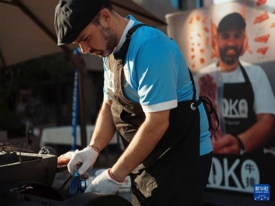 7月19日，在蕪湖古城，馬丁在當(dāng)天舉行的啤酒節(jié)上制作牛排。新華社發(fā)（繆雨晨 攝）