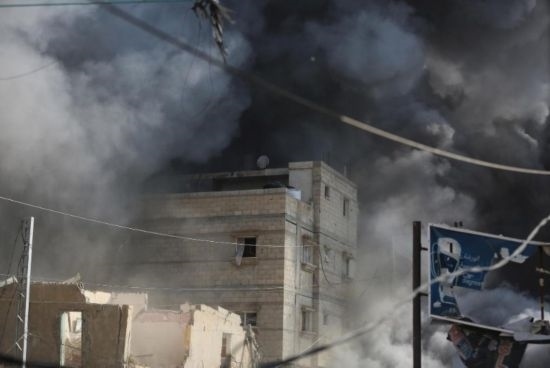 7月21日，在加沙地帶中部的努賽賴特難民營，遭以軍空襲的建筑冒出滾滾濃煙。新華社發(fā)（馬爾萬·達烏德攝）