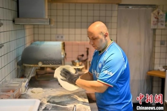 近日，韋榮耀在自家披薩小店內(nèi)忙活。俞靖 攝