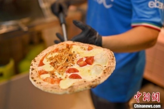 近日，韋榮耀展示他制作的“老友味”披薩。 俞靖 攝