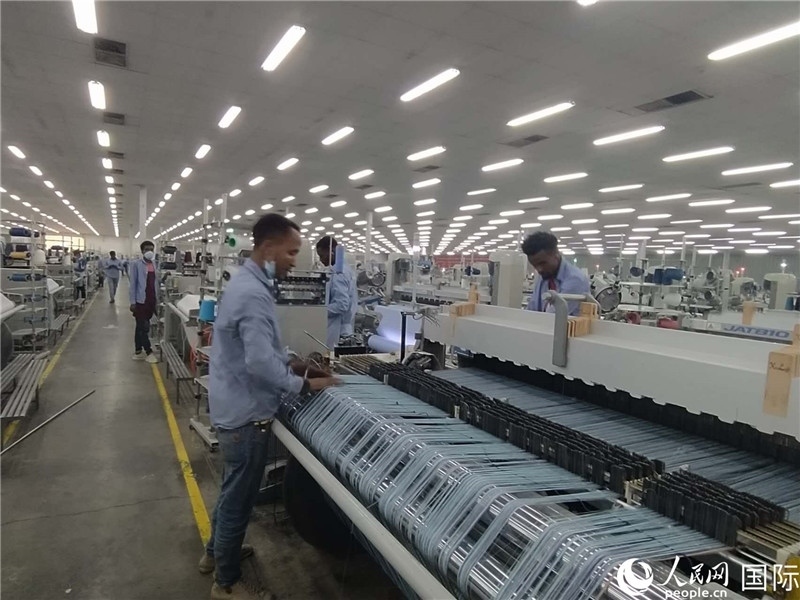 無(wú)錫金茂埃塞面料廠車(chē)間內(nèi)，當(dāng)?shù)毓と苏谝唤z不茍地作業(yè)。人民網(wǎng)記者 黃培昭攝