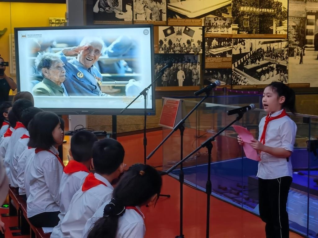 南京市科睿小學(xué)二年級學(xué)生章若初為大家講述抗戰(zhàn)老兵手印的故事。 新華社記者 邱冰清 攝