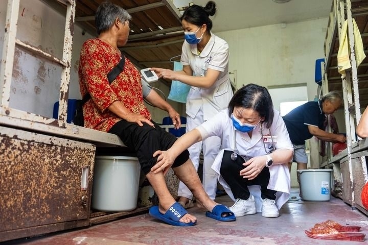 2024年7月30日，在湖南省湘潭縣河口中學(xué)安置點(diǎn)，醫(yī)務(wù)人員為受洪水影響而轉(zhuǎn)移安置的群眾檢查身體。 新華社記者 陳思汗 攝