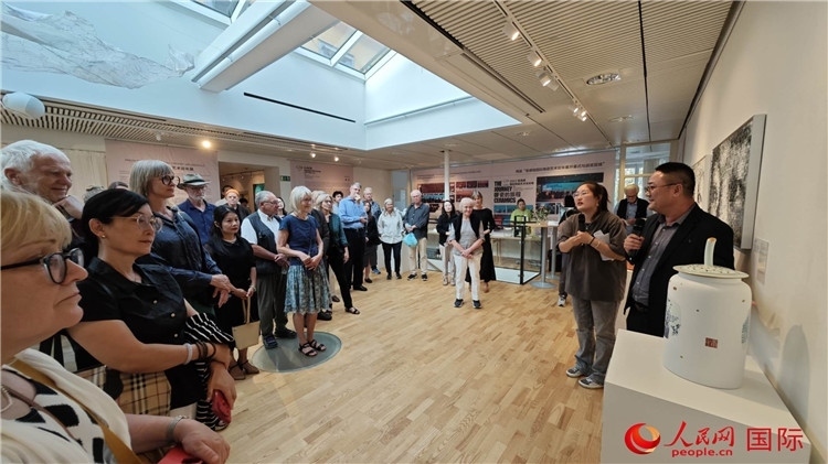 參展人、景德鎮(zhèn)陶瓷大學(xué)美術(shù)學(xué)院副院長(zhǎng)邵長(zhǎng)宗（右一）向來(lái)賓介紹參展作品。人民網(wǎng)記者 殷淼攝