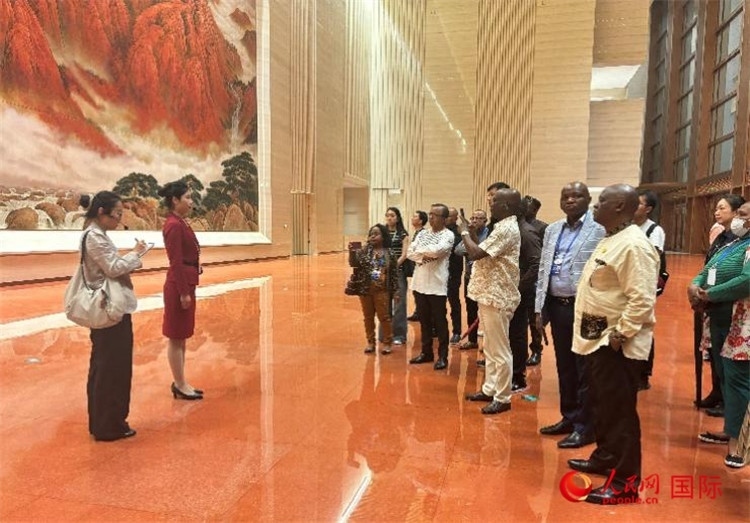 代表團(tuán)在入口處聽取講解。人民網(wǎng) 曹欣悅攝