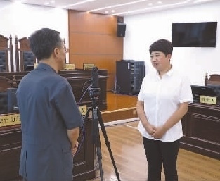 圖為全國人大代表玉明姬（右）詳細(xì)了解環(huán)境資源審判工作情況。劉思妤 攝