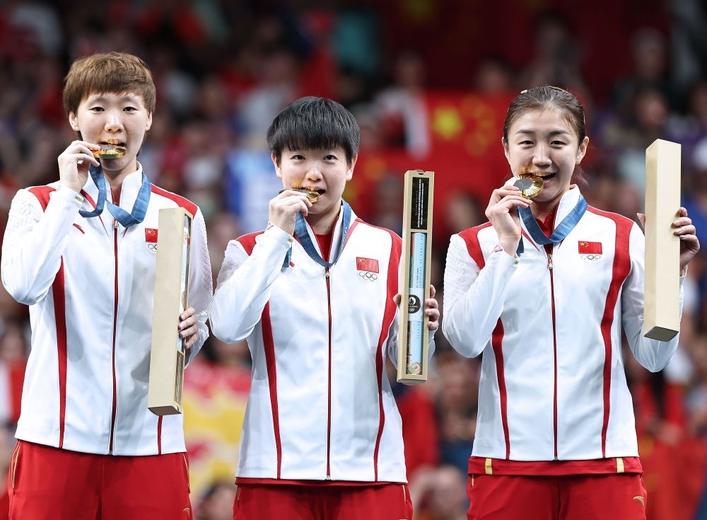 冠軍中國隊(duì)選手王曼昱、孫穎莎、陳夢（從左至右）在巴黎奧運(yùn)會(huì)乒乓球女子團(tuán)體頒獎(jiǎng)儀式上（2024年8月10日攝）。新華社記者 王東震 攝