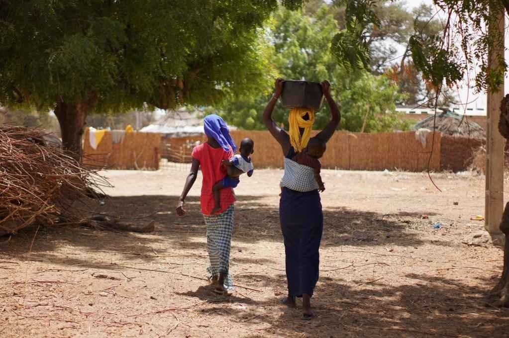 2023年3月20日，在塞內(nèi)加爾久爾貝勒區(qū)的泰內(nèi)富勒村，村民將取到的水運(yùn)回家。新華社記者 王子正 攝