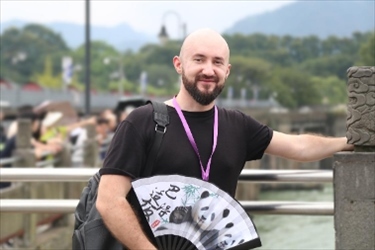 俄羅斯塔斯社執(zhí)行編輯葉夫根尼·扎多羅日內(nèi)在都江堰魚嘴拍照留念。（李佩藺 攝）