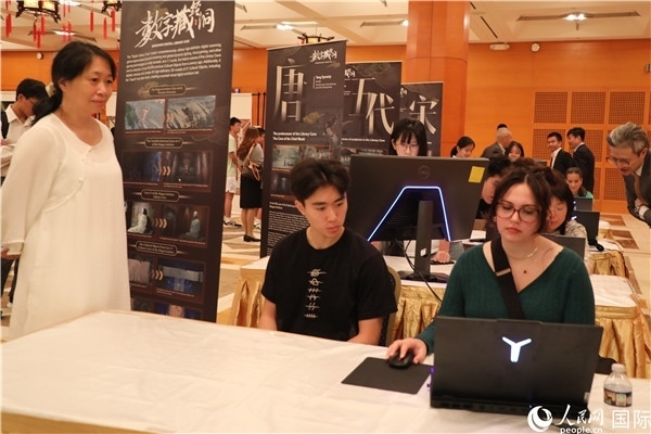 在活動(dòng)現(xiàn)場(chǎng)，當(dāng)?shù)孛癖婓w驗(yàn)“數(shù)字藏經(jīng)洞”云游戲，沉浸式體驗(yàn)敦煌文化。 人民網(wǎng)記者 李志偉攝