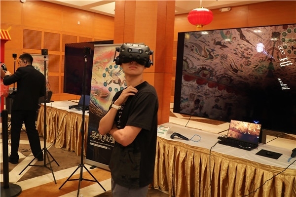 1、在本次活動(dòng)的展覽現(xiàn)場(chǎng)，敦煌研究院與騰訊展示了“數(shù)字藏經(jīng)洞”和“尋境敦煌”等創(chuàng)新互動(dòng)產(chǎn)品。圖為當(dāng)?shù)孛癖娡ㄟ^VR虛擬游覽洞窟。 人民網(wǎng)記者 李志偉攝