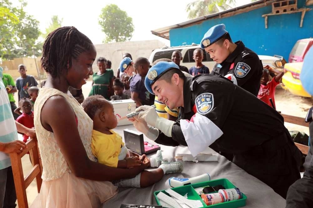 2017年12月28日，在利比里亞蒙羅維亞，中國(guó)維和警察防暴隊(duì)醫(yī)療人員為兒童做口腔檢查。