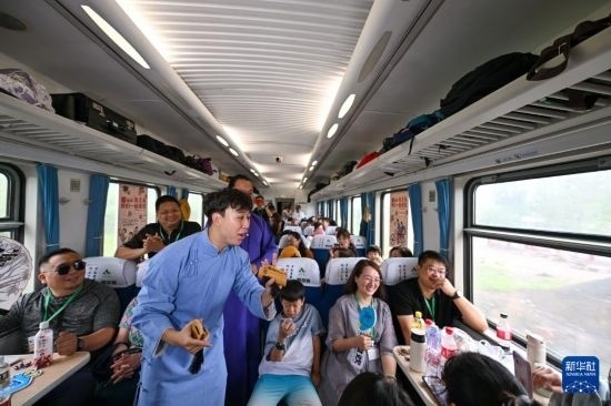9月7日，相聲演員在S910列車上為旅客表演快板。