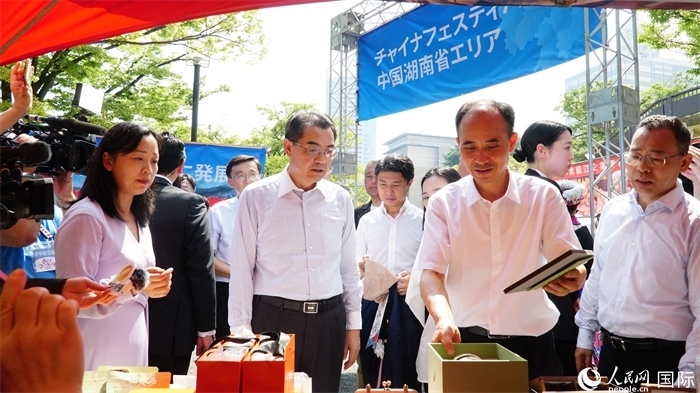 湖南展位工作人員向中國(guó)駐日本大使吳江浩介紹特色文創(chuàng)產(chǎn)品。人民網(wǎng) 蔣曉辰攝