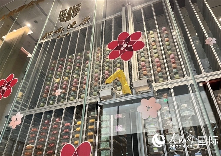 6. 機(jī)械臂正在取貨。（人民網(wǎng)記者陳思 攝）