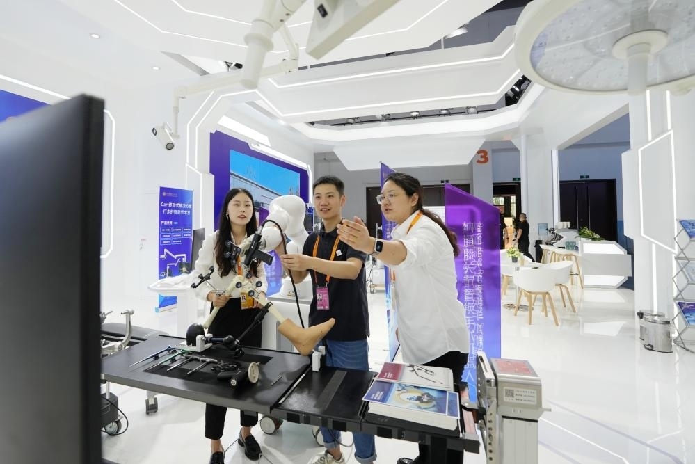 9月11日，一位媒體記者（中）在2024年服貿(mào)會國家會議中心會場體驗北京納通科技集團(tuán)有限公司的膝關(guān)節(jié)置換手術(shù)機(jī)器人。新華社記者鞠煥宗 攝