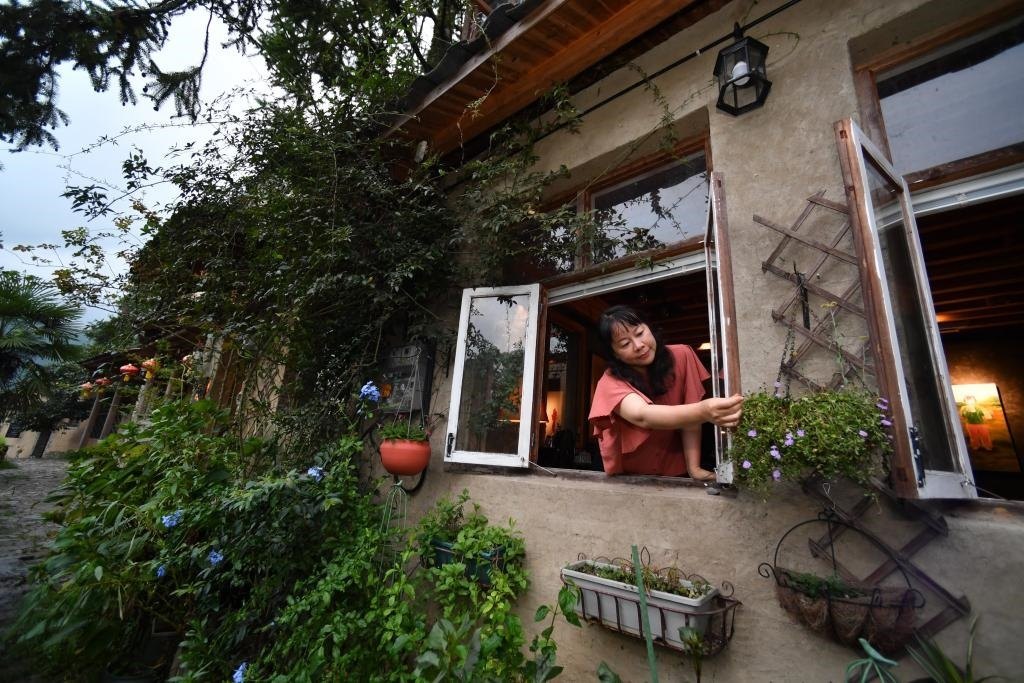 8月29日，在福建省屏南縣熙嶺鄉(xiāng)，龍?zhí)洞濉靶麓迕瘛泵泛暝诖蚶碜约航洜I的民宿外墻裝飾花盆。新華社記者姜克紅 攝