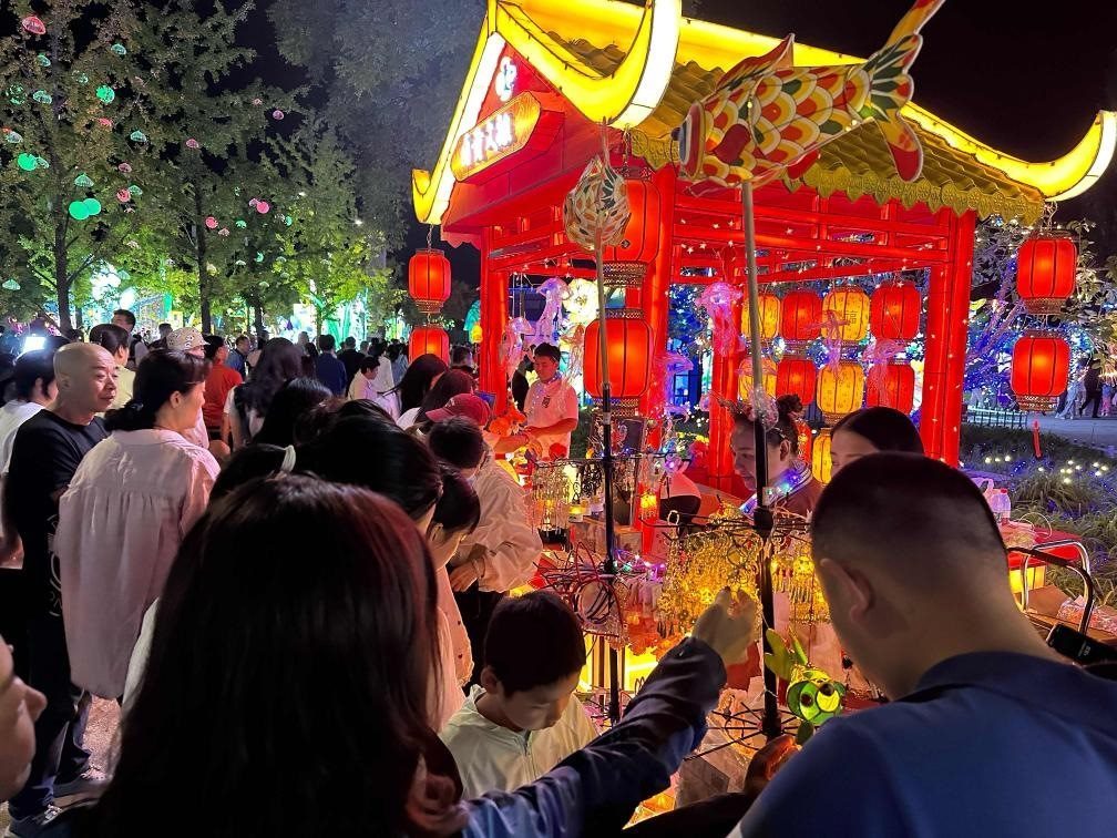 市民游客在2024年北京中秋國慶彩燈游園會(huì)上選購特色文創(chuàng)商品。新華社記者楊淑君 攝
