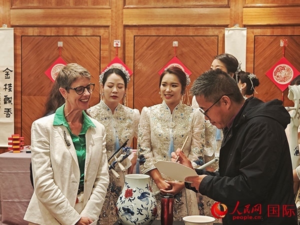 現(xiàn)場的非遺傳承人為英國觀眾展示畫技。人民網(wǎng)記者 邢雪攝