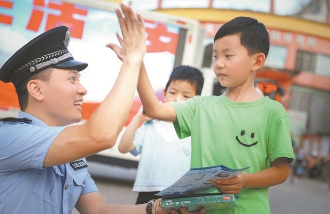 ▲7月10日，江西省吉安市公安局吉州分局組織民警深入轄區(qū)開展安全宣傳，民警向小朋友講解防溺水知識。朱文杰攝