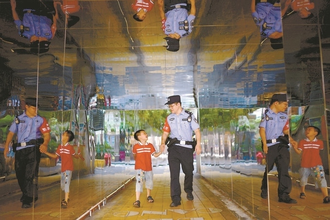 ?7月16日，重慶市公安局江北區(qū)分局一名民警在巡邏途中遇到一個獨自玩耍的小男孩，民警將其送回家。王洪平攝