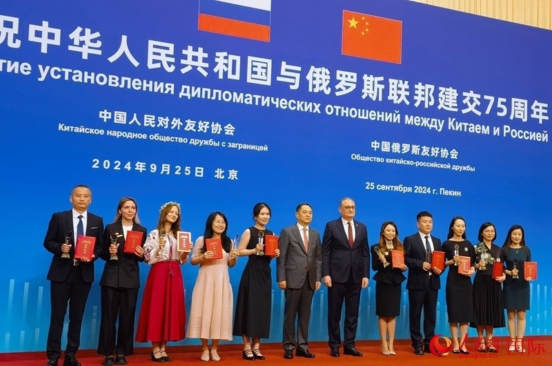 楊萬(wàn)明會(huì)長(zhǎng)和莫爾古洛夫大使為10位中俄青年友好微視頻創(chuàng)意大賽獲獎(jiǎng)代表頒獎(jiǎng)。人民網(wǎng)記者 李明琪攝