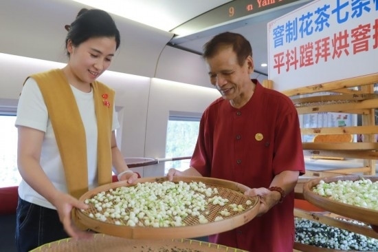 10月1日，福州市茉莉花茶窨制工藝代表性傳承人張子建與旅客在G1634次列車上制作茉莉花茶。新華社記者周義 攝