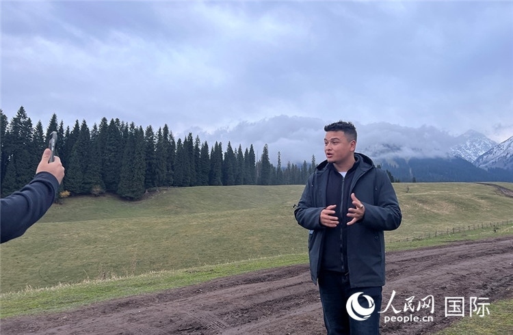 在庫爾德寧，吾買爾江被雪山美景震撼，即興錄制了短視頻作品。人民網(wǎng)記者曾書柔攝