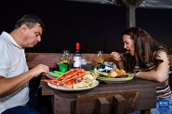 9月2日，食客們在俄羅斯符拉迪沃斯托克的一家餐館品嘗帝王蟹。新華社記者 曹陽 攝