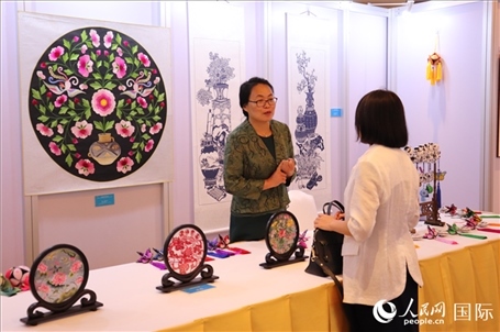 青海非遺文化傳承人向嘉賓介紹展品。人民網(wǎng)實(shí)習(xí)生姚欣可攝