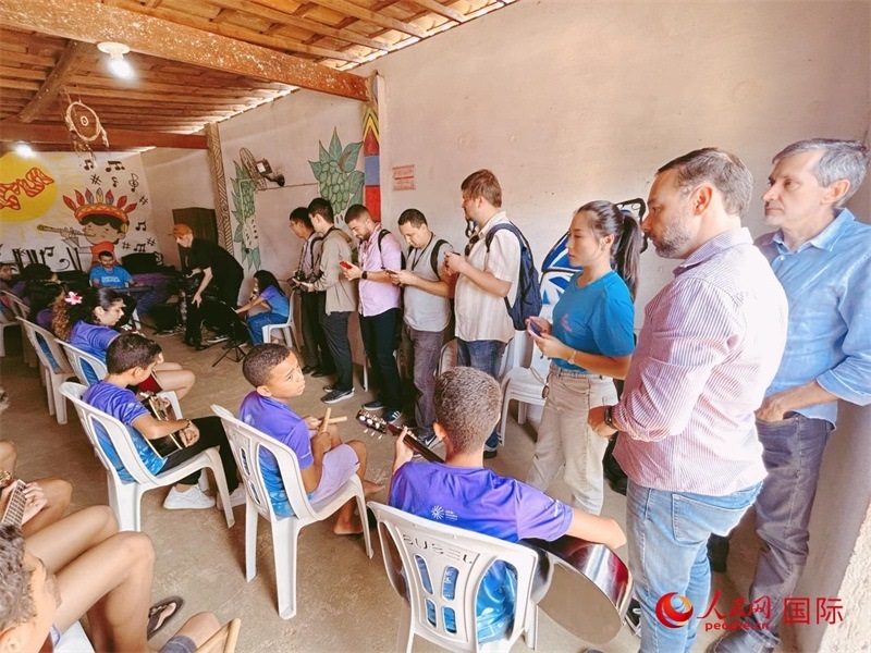  受益于中國企業(yè)的“青少年成長”項目，700多名當(dāng)?shù)厍嗌倌甑囊魳泛妥闱驂粝氩迳狭顺岚?。圖為聯(lián)合采訪團(tuán)正在采訪參加音樂培訓(xùn)的孩子們。 人民網(wǎng)記者 陳一鳴攝