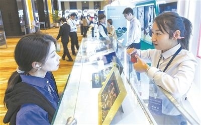 在北京麗澤商務(wù)區(qū)，工作人員（右一）介紹數(shù)字人民幣SIM卡硬錢包。新京報記者 陶冉攝