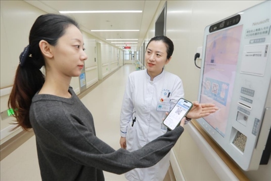 醫(yī)護人員引導患者在自助機前辦理自助入院手續(xù)。圖片來源：山東第一醫(yī)科大學第二附屬醫(yī)院