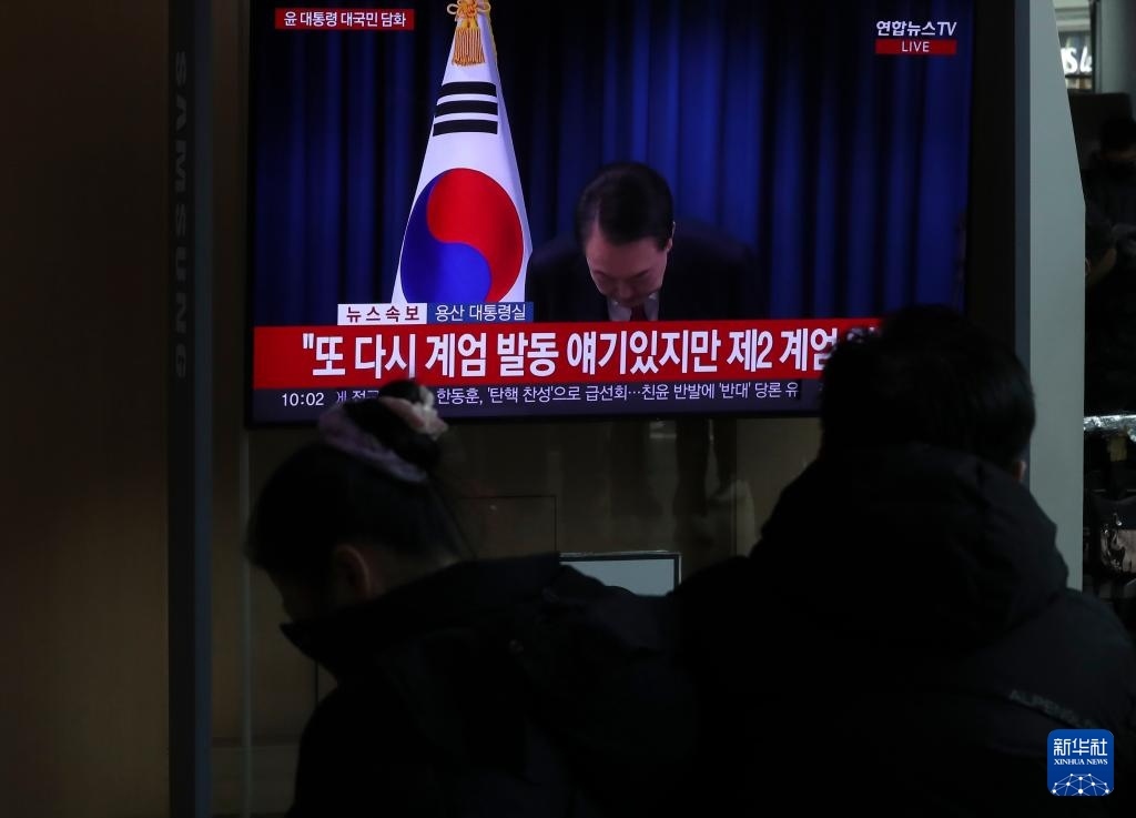 12月7日，在韓國(guó)首爾火車站，民眾觀看總統(tǒng)尹錫悅發(fā)表講話的電視畫面。新華社記者 姚琪琳 攝