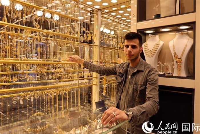 一名銷(xiāo)售員展示黃金飾品。人民網(wǎng) 伊納斯·易卜拉欣攝