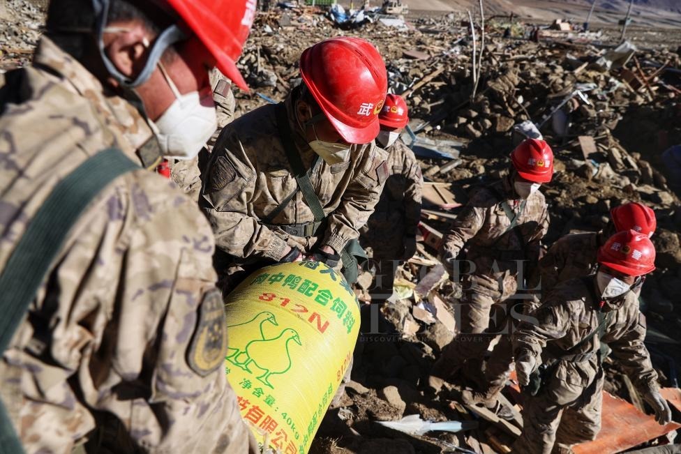 1月10日，定日縣長所鄉(xiāng)古榮村，武警官兵幫助受災群眾整理廢墟，搶救被掩埋的物資。環(huán)球時報記者崔萌攝