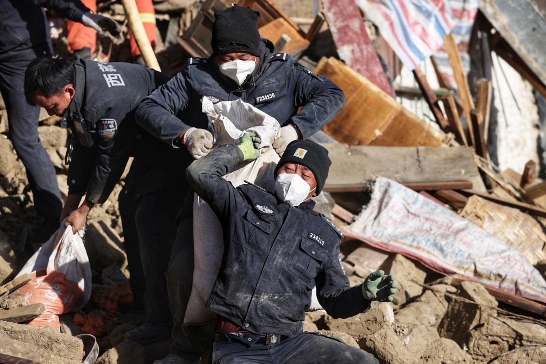 1月9日，定日縣長所鄉(xiāng)古榮村，日喀則市公安局民警協助受災群眾清理廢墟。 環(huán)球時報記者 崔萌攝