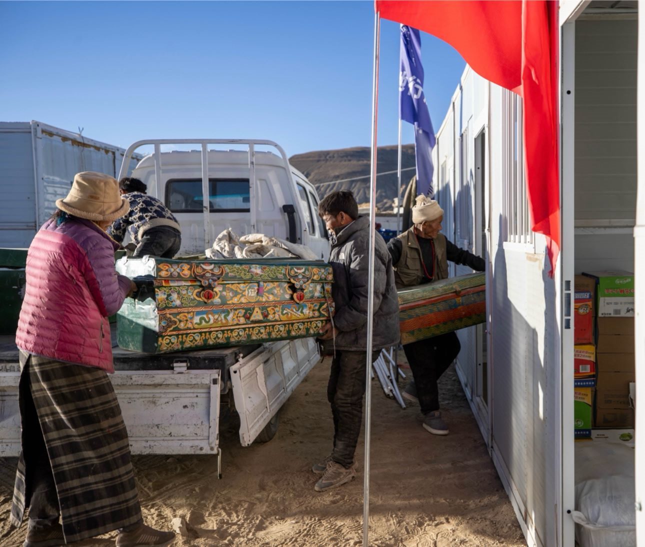 1月11日，西藏定日縣曲洛鄉(xiāng)措昂村，首批入住活動板房的村民正在搬運物品，為入住做準備。人民日報記者張武軍攝