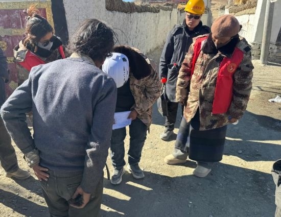 1月13日，次旺（右一）陪同工作組走訪村莊，評估房屋受損程度。新華社發(fā)