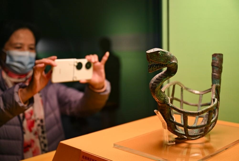 1月14日，觀眾在上海博物館蛇年迎春展拍攝展品蛇綱網(wǎng)狀銅器。新華社發(fā)（陳浩明攝）