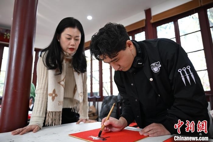 1月20日，外籍留學(xué)生在西泠印社社員李硯指導(dǎo)下寫(xiě)福。當(dāng)日，來(lái)自巴西、馬來(lái)西亞、加納、哈薩克斯坦的外籍留學(xué)生在浙江杭州西泠印社體驗(yàn)福貼、春聯(lián)和篆刻，感受古老的中國(guó)傳統(tǒng)文化。中新社記者 王剛 攝