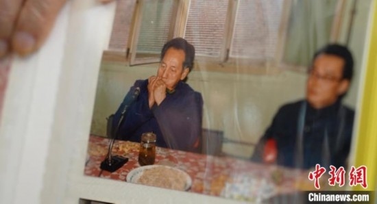 2月7日，劉潤林展示1986年黃旭華(左)在同樂會上吹口琴的老照片。中新社記者 鄒浩 攝