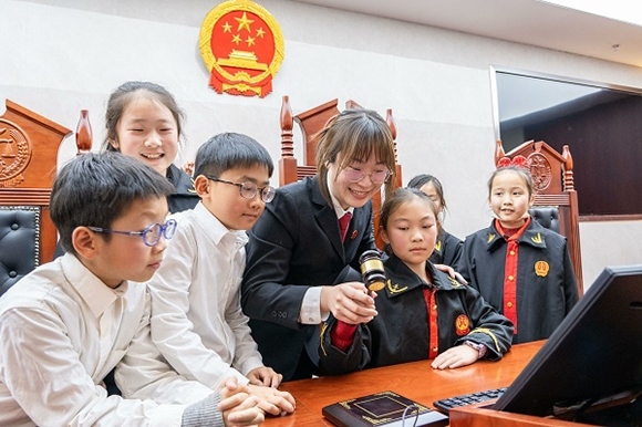 圖①：干警帶同學們體驗敲法槌。