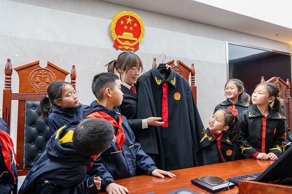 圖②：干警向同學們介紹法袍。